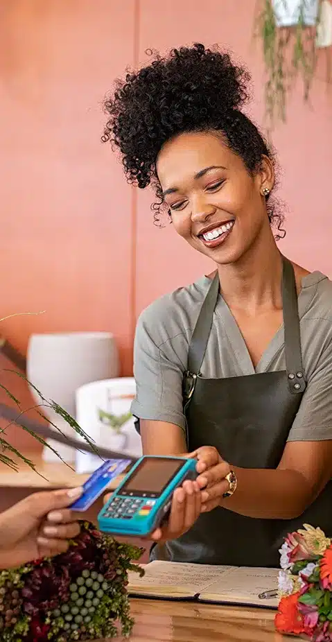 A small business owner taking a card payment in her flower shop