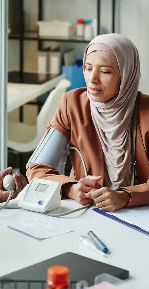 A lady having her blood pressure taken in a doctors office