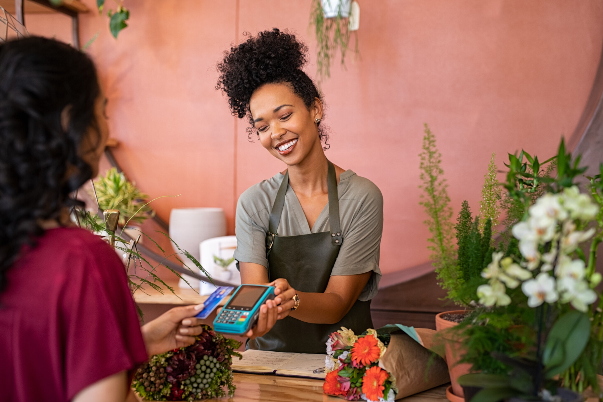 A small business owner taking a card payment in her flower shop