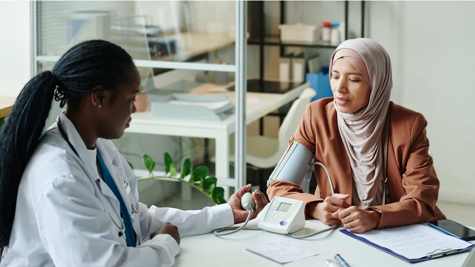 A doctor takes the blood pressure of a patient in a healthcare office.